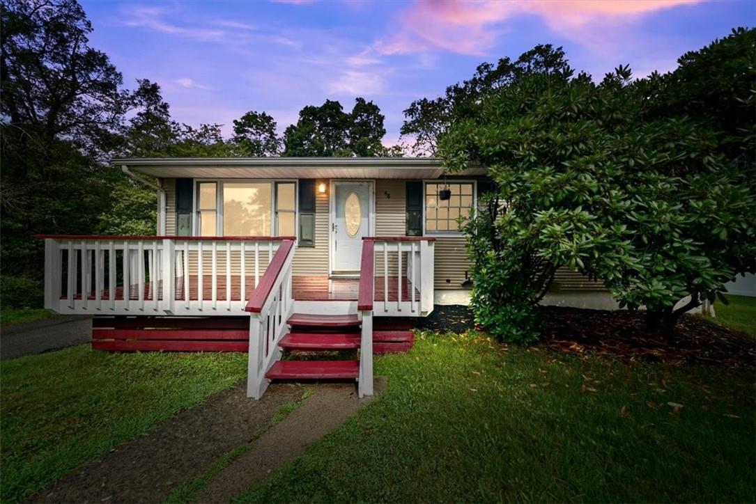 a view of backyard of house with deck and seating space