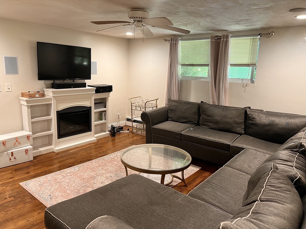 a living room with furniture a flat screen tv and a fireplace