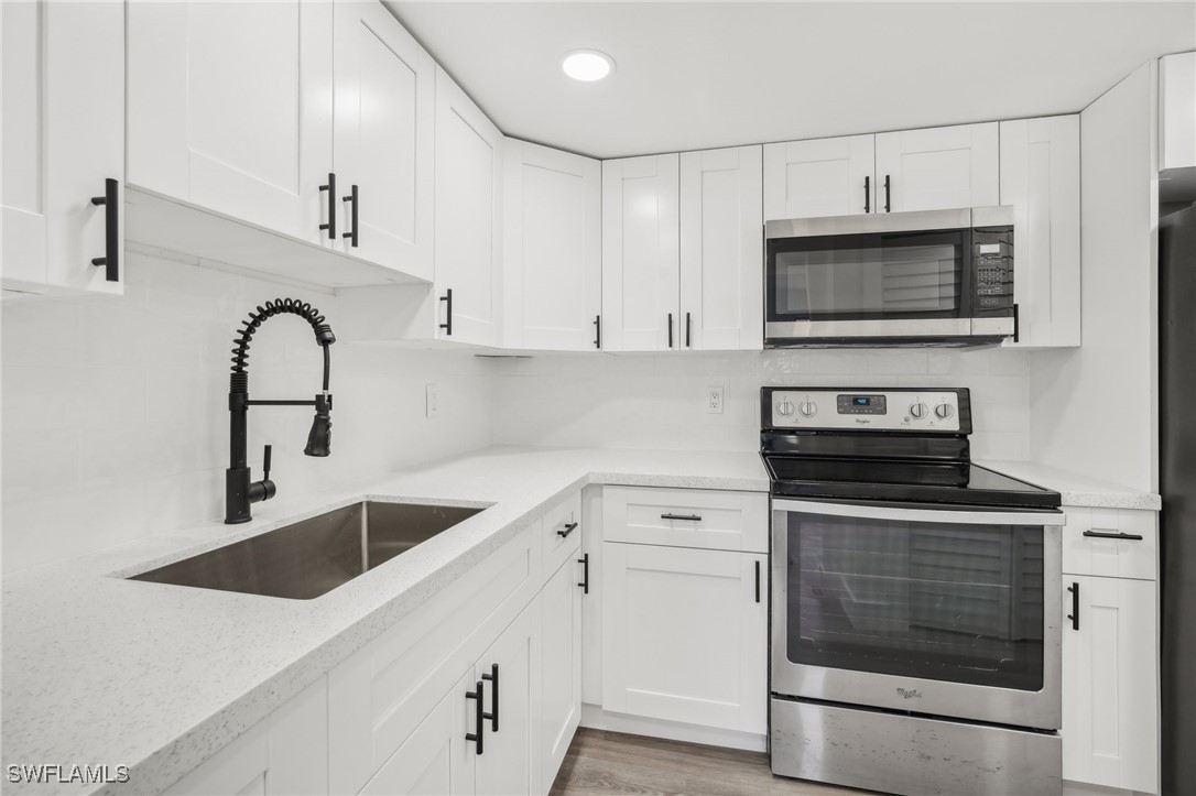 a kitchen with stainless steel appliances granite countertop a sink and a stove top oven