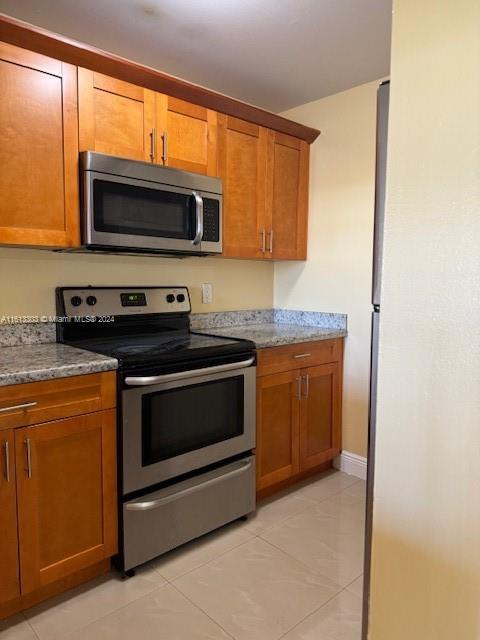 a kitchen with stainless steel appliances granite countertop a stove microwave and sink