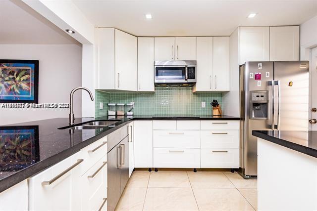 a kitchen with granite countertop a sink stove and refrigerator