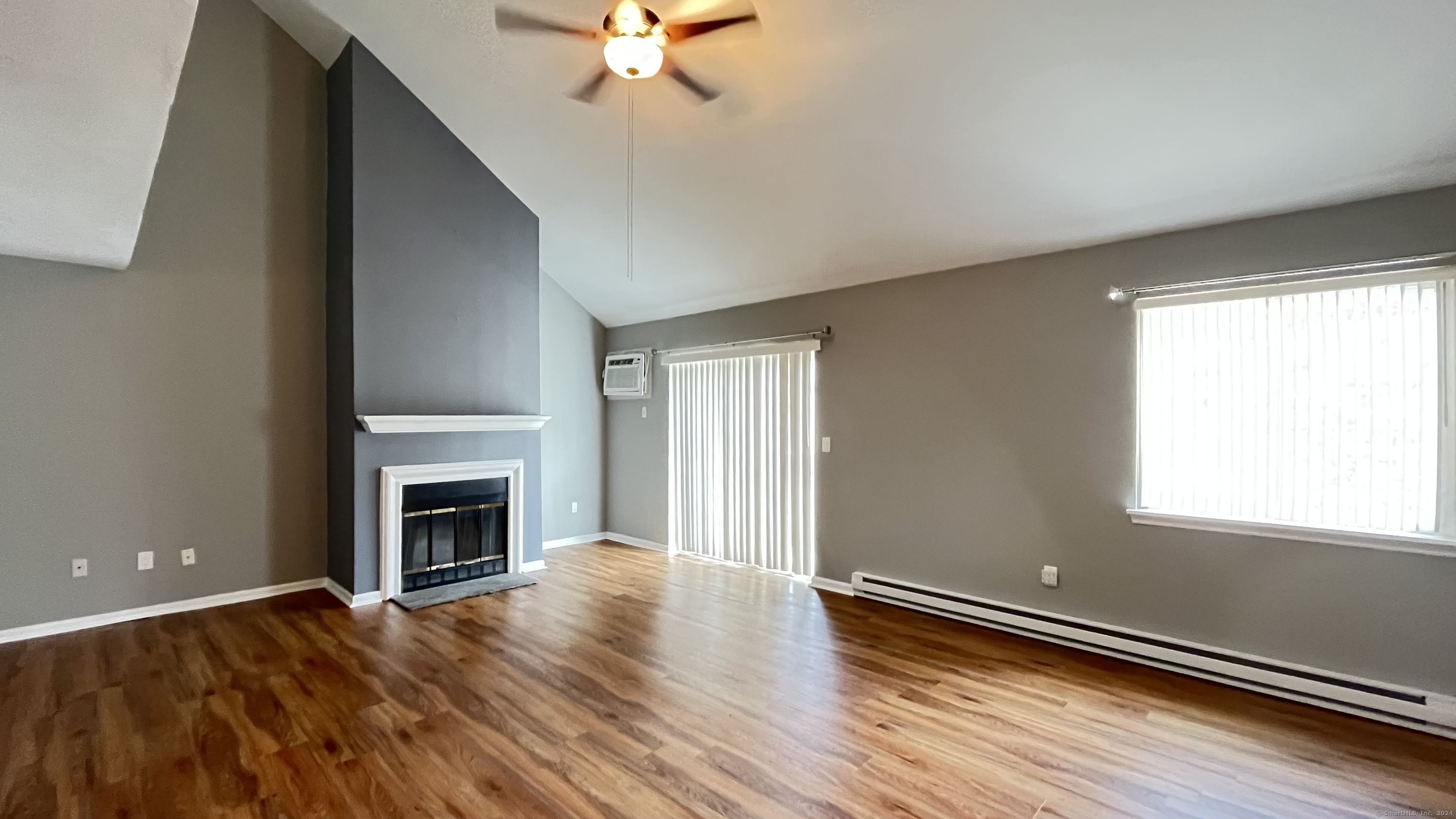 wooden floor fireplace and natural light in room