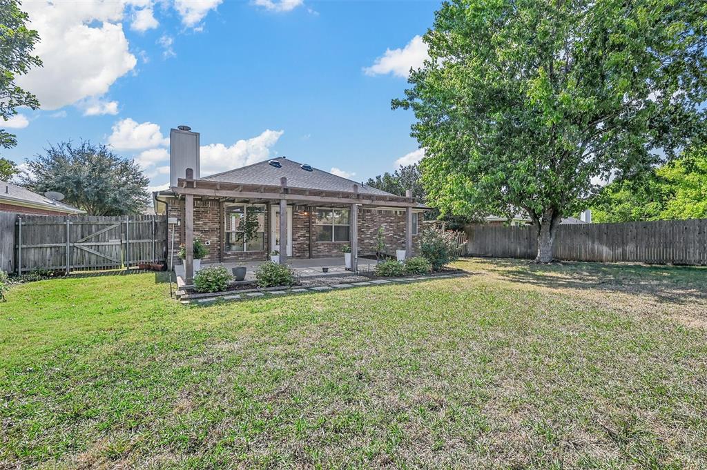 Rear view of property featuring a patio area, a lawn, and a pergola