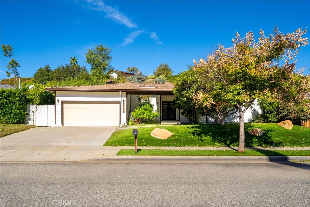 a view of a house with a small yard and potted plants