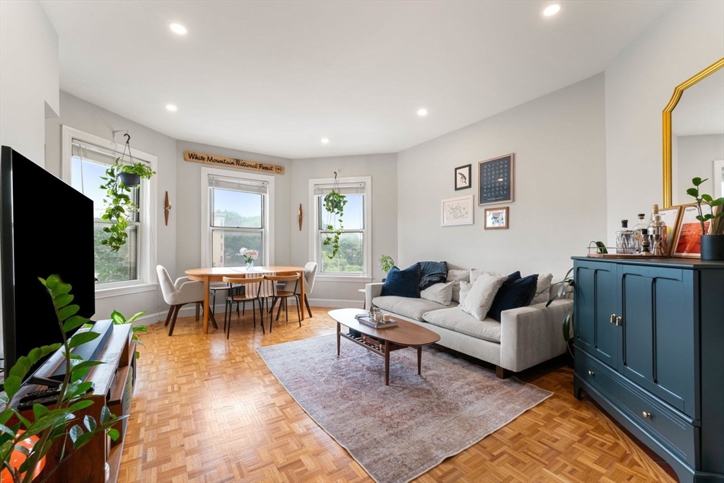 a living room with furniture a large window and a flat screen tv