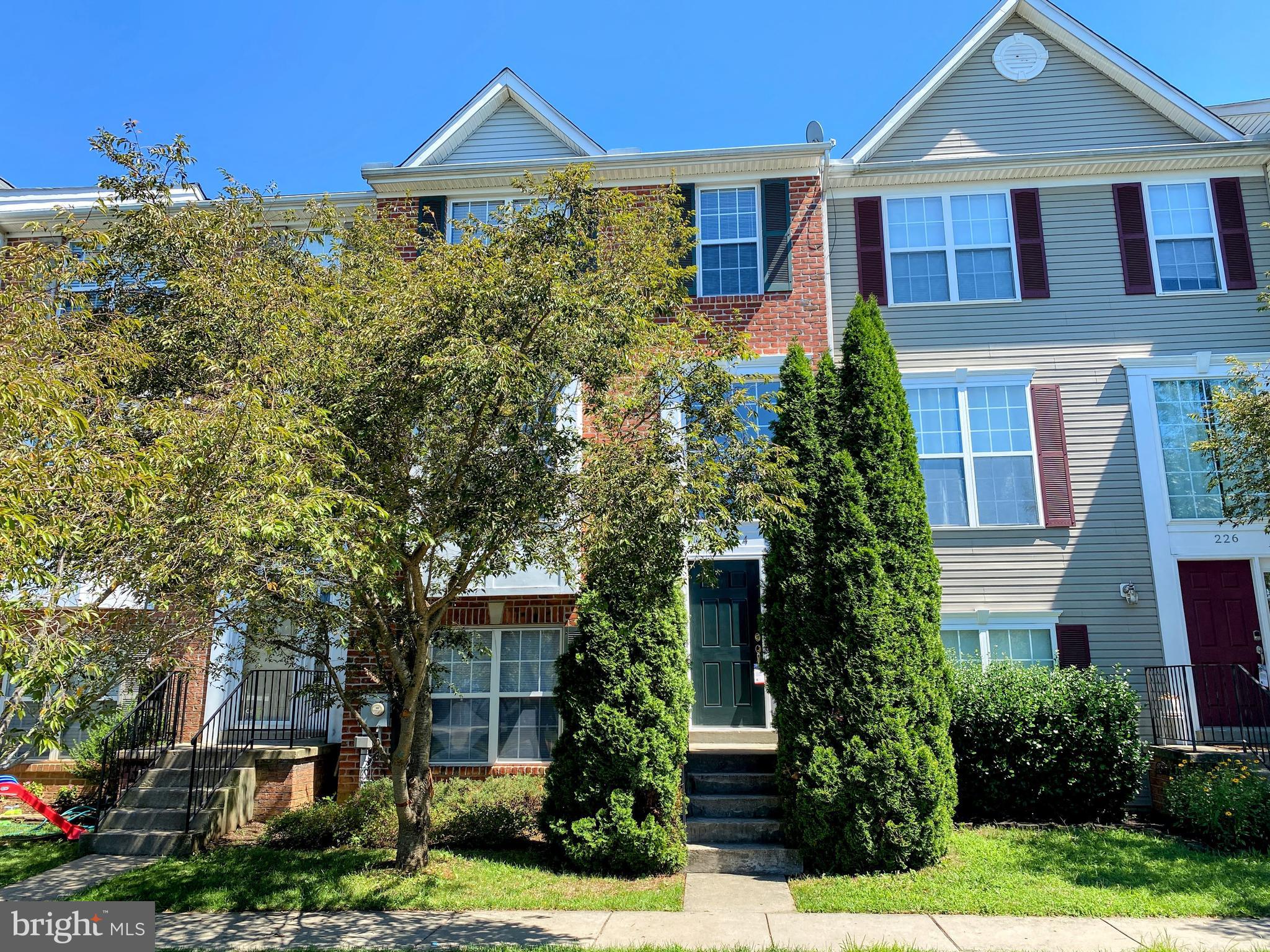 a front view of a house with a yard and potted plants