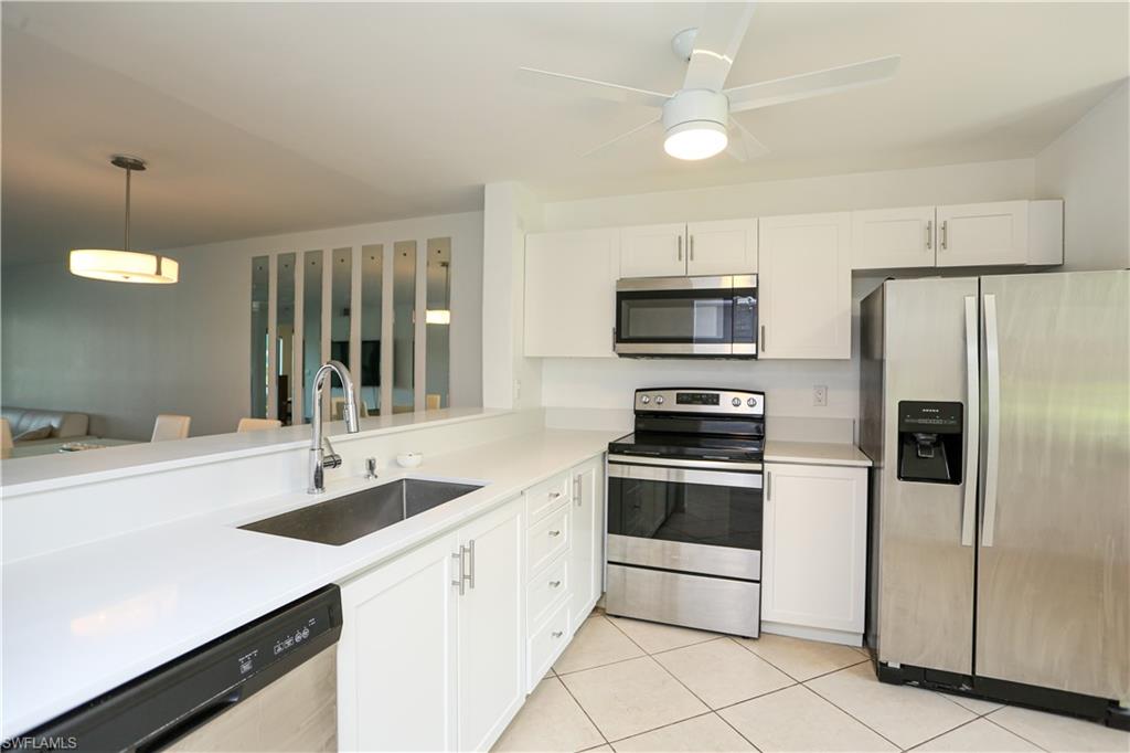 a kitchen with sink a microwave and refrigerator