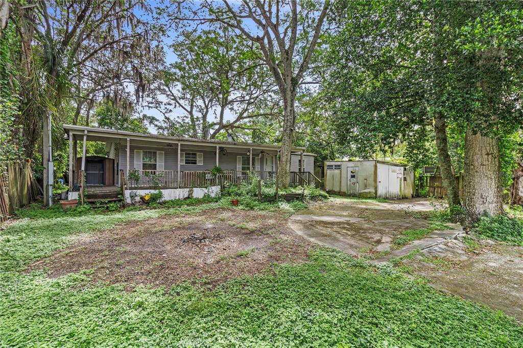 a front view of house with a garden and trees