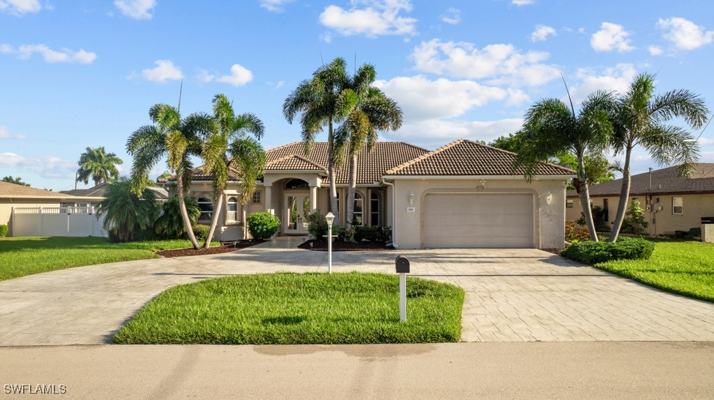 a front view of a house with a garden and palm trees