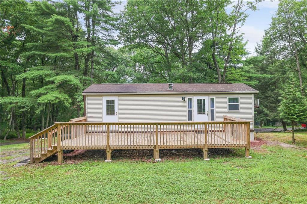 a view of a house with a backyard and deck