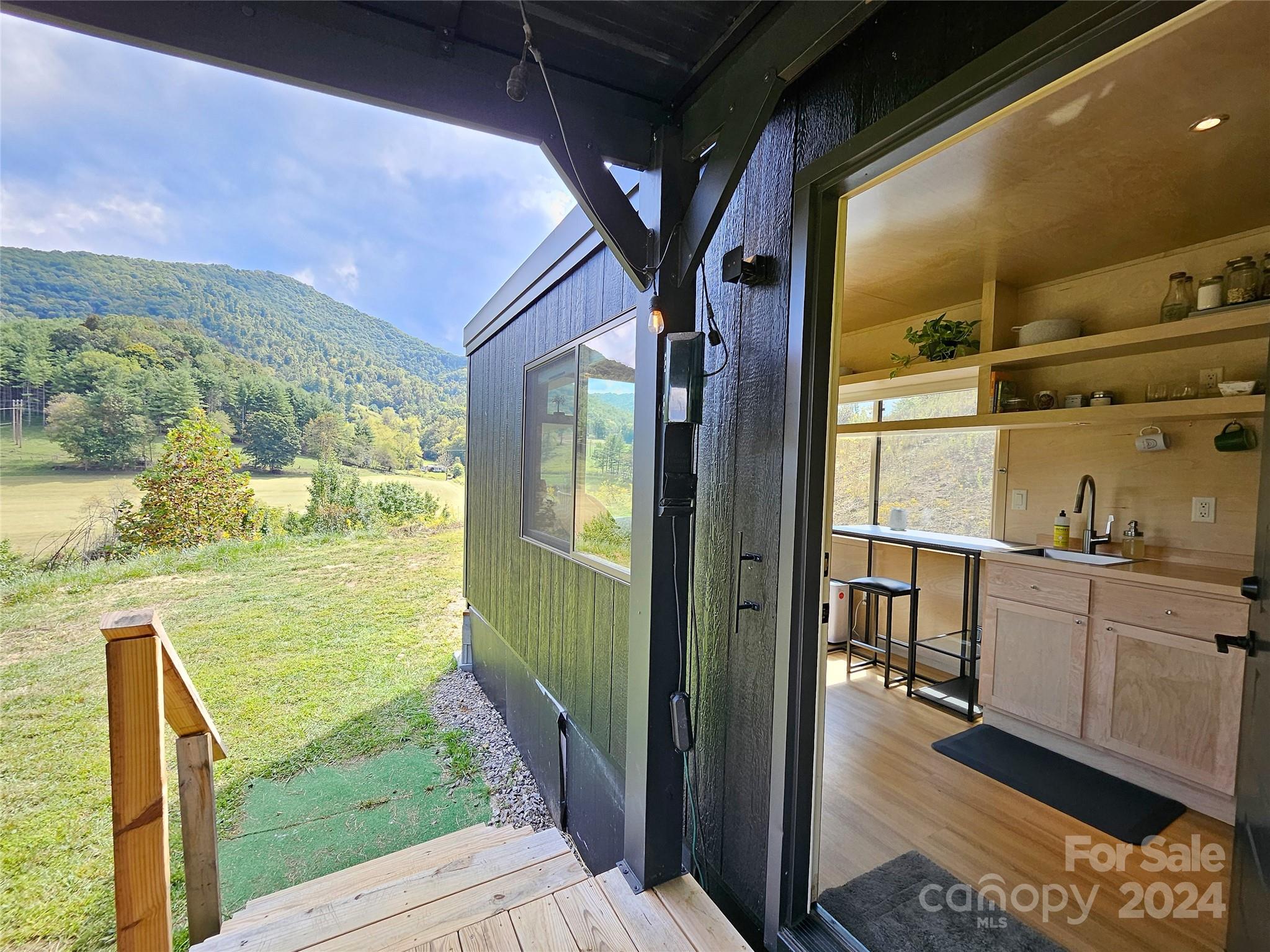 a view of living room and kitchen with wooden floor