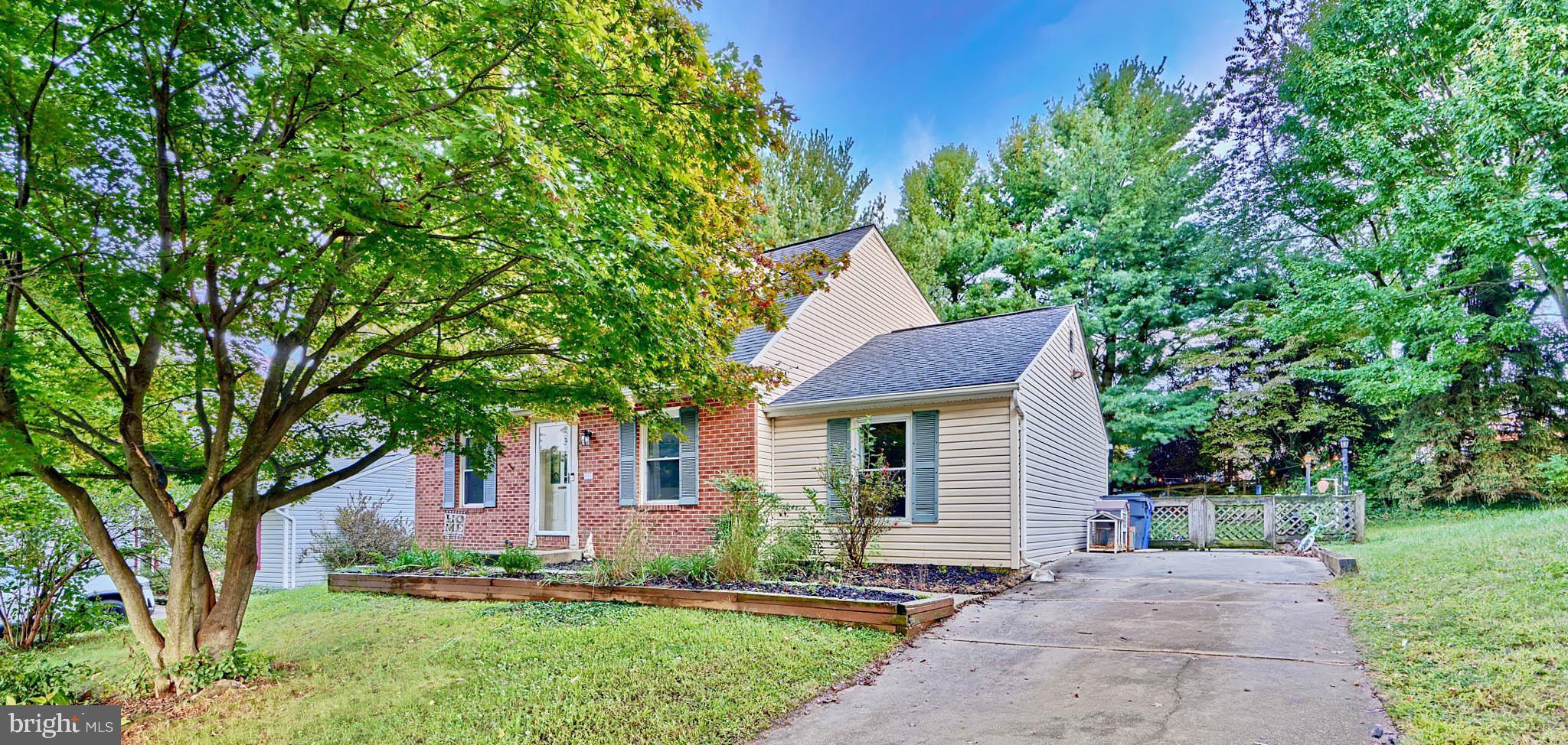 a front view of a house with a yard and trees