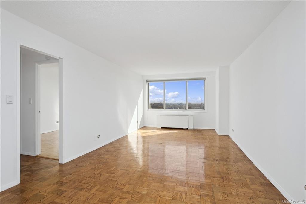 Unfurnished room featuring parquet flooring and radiator heating unit