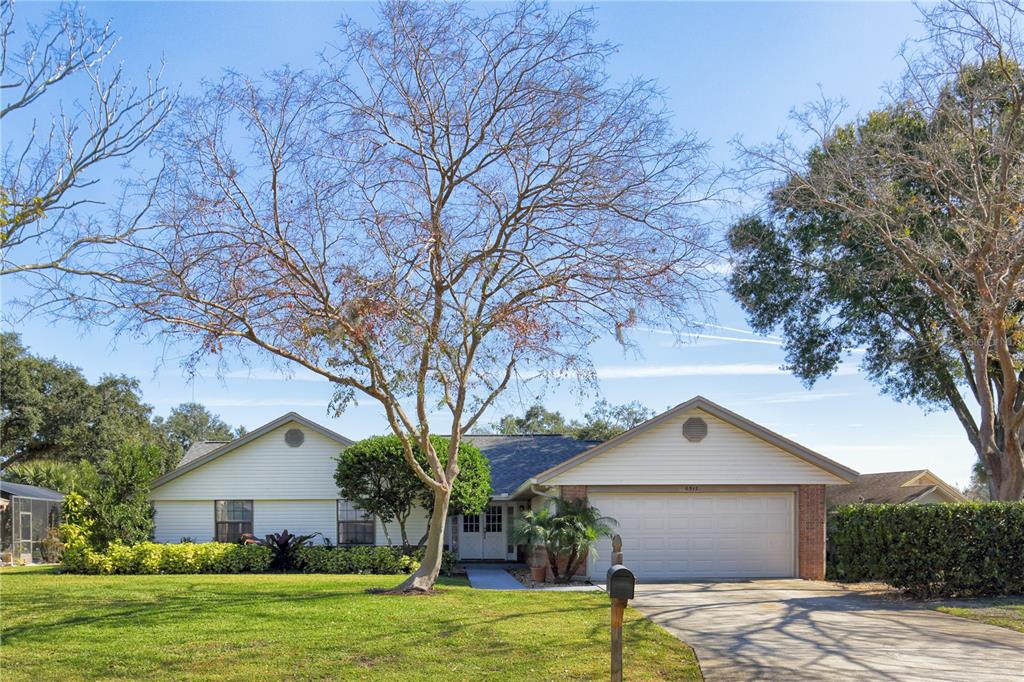 a front view of a house with a yard and tree