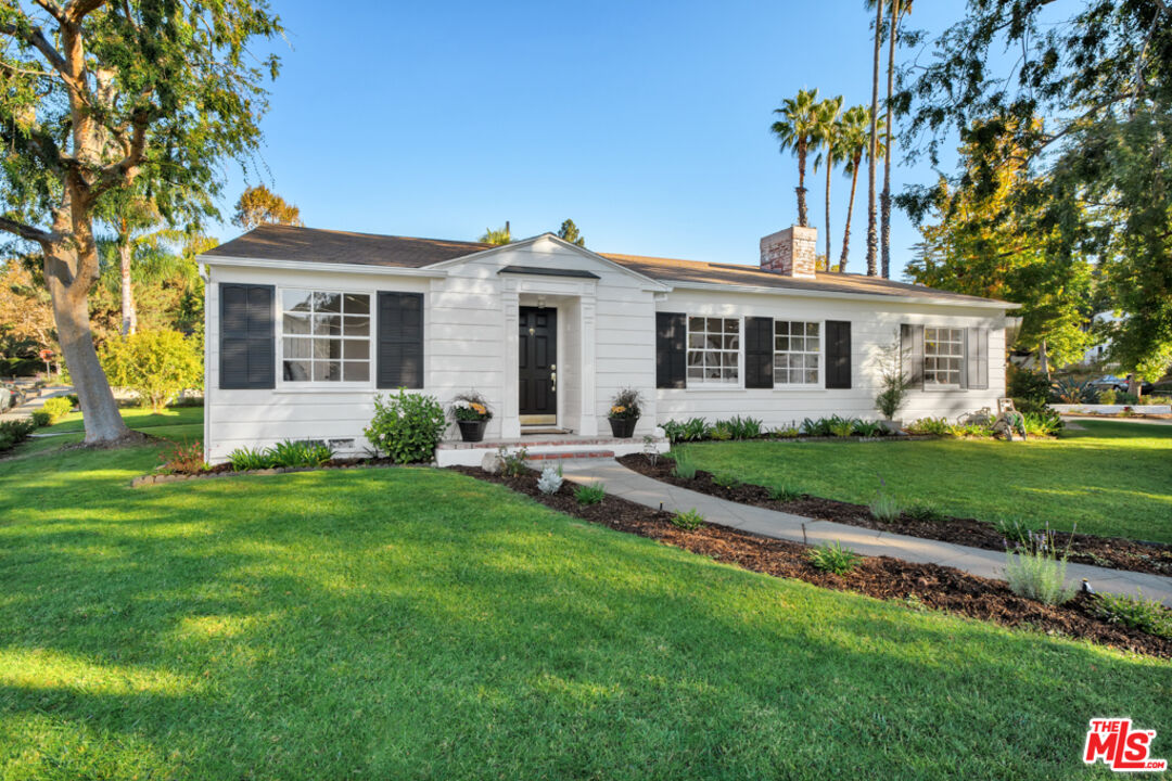 a front view of a house with a garden and plants