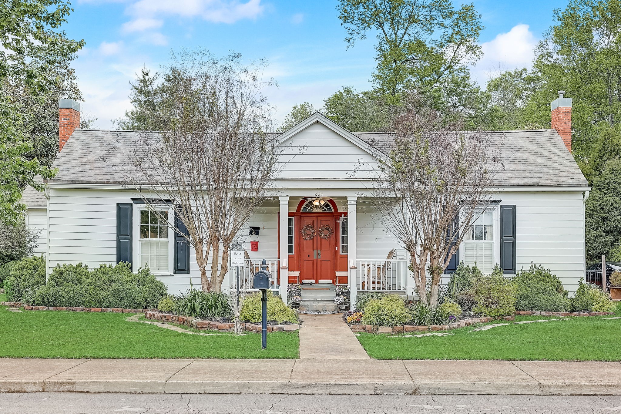 a front view of a house with a yard and potted plants