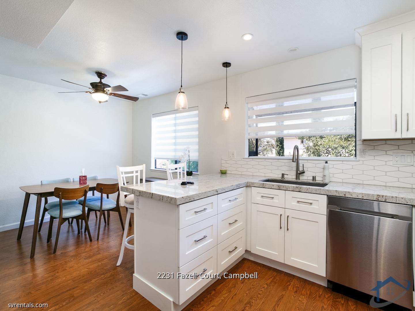 a kitchen with a stove a sink a window and chairs