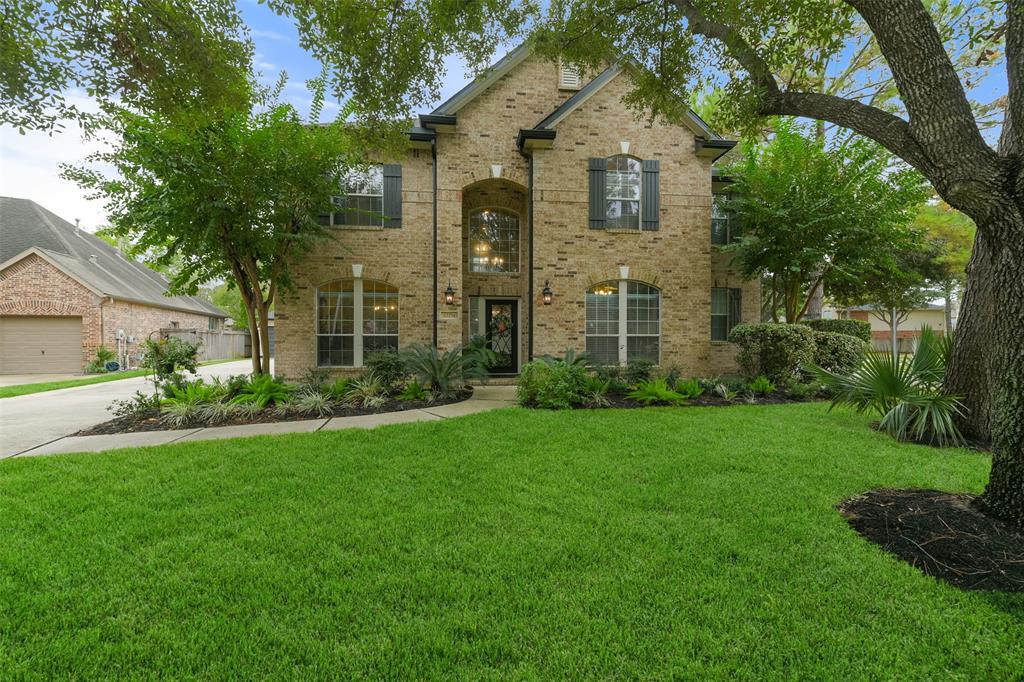 a front view of a house with a yard and trees