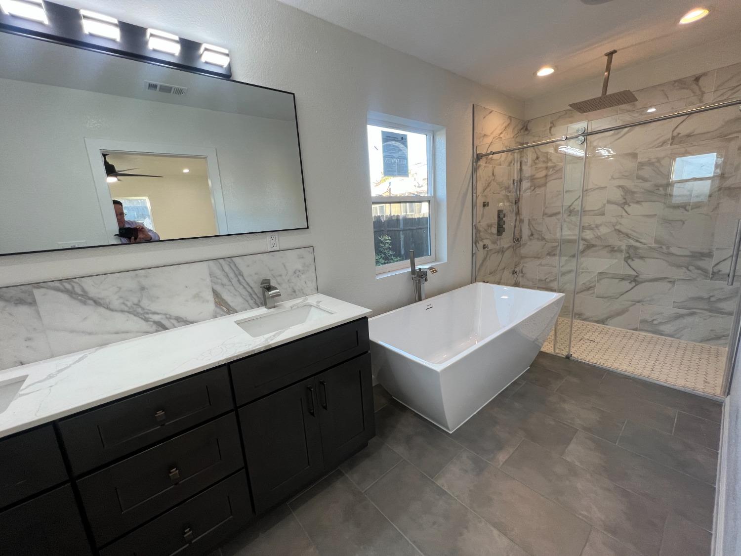 a bathroom with a bathtub a sink and mirror