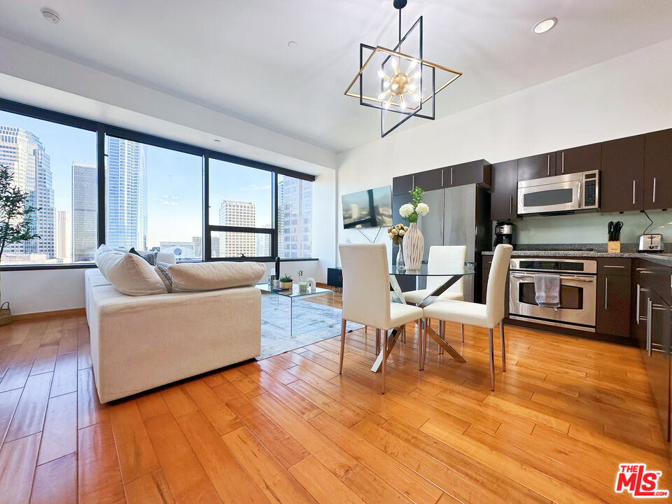 a living room with furniture wooden floor and a dining table