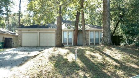 a backyard of a house with large trees and covered with wooden fence