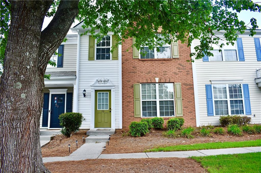 a front view of a house with yard and green space