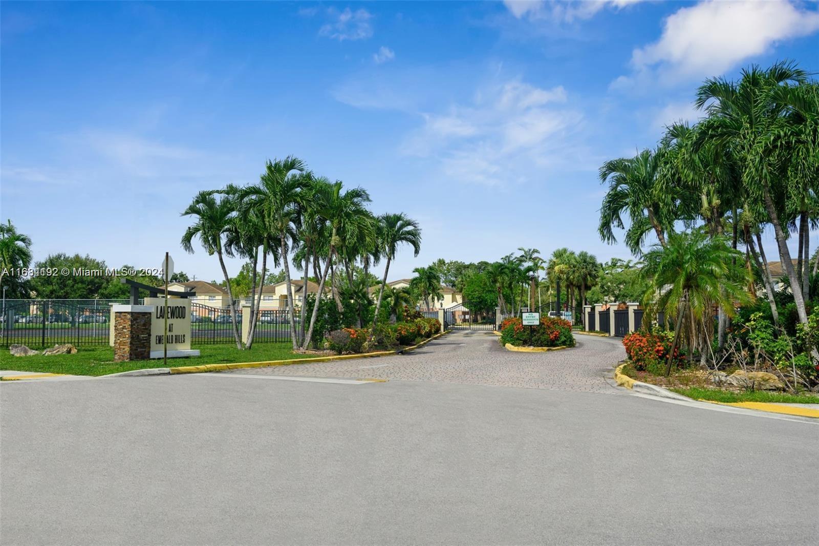 a view of swimming pool with a yard and palm trees