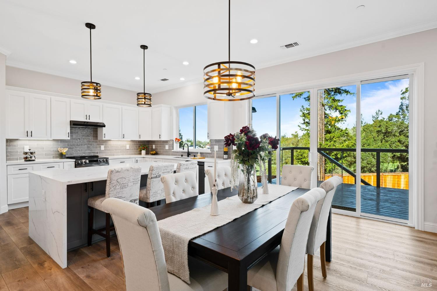 a dining room with furniture a chandelier and kitchen view