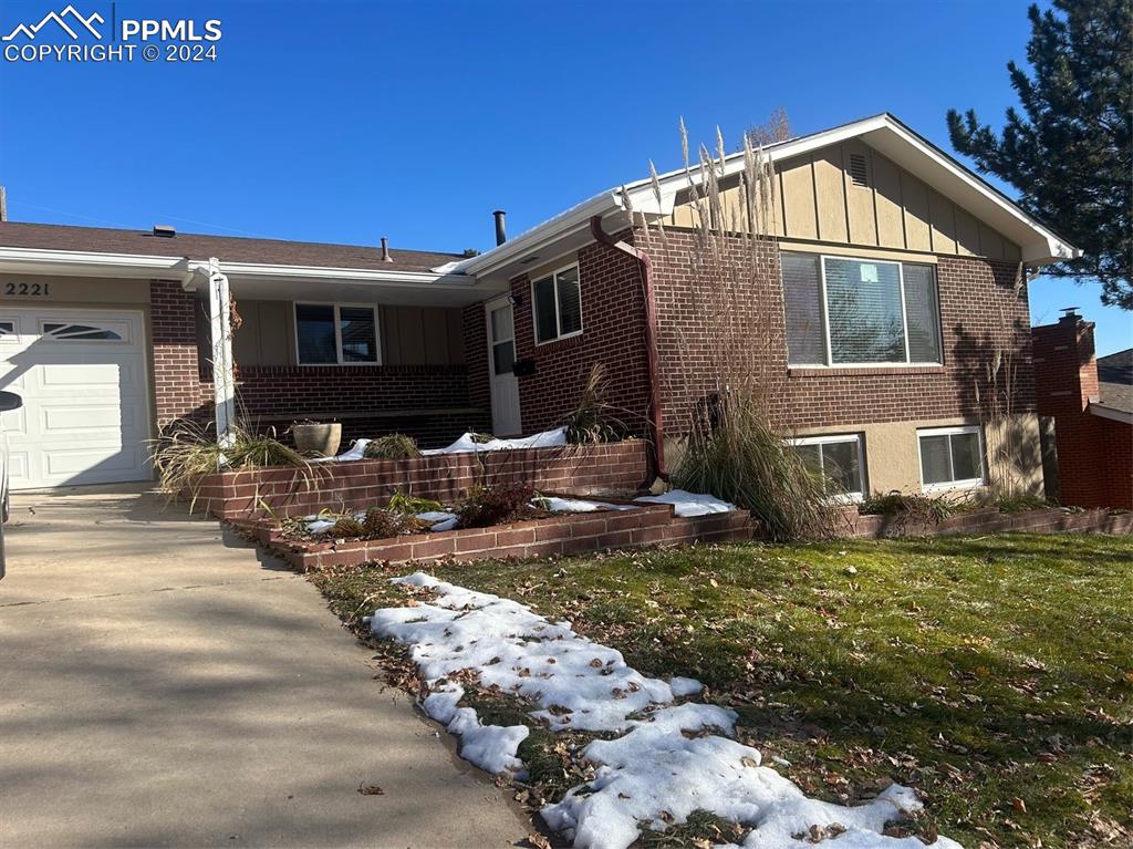 View of front of home featuring a front yard and a garage