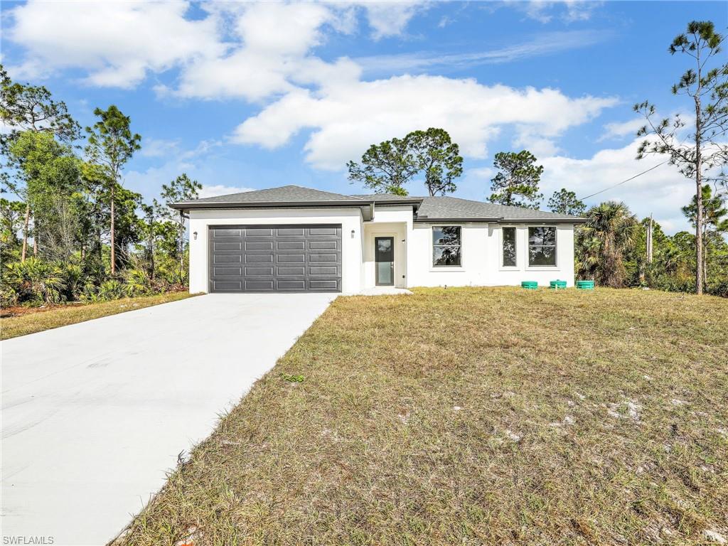 View of front of house with a front yard and a garage