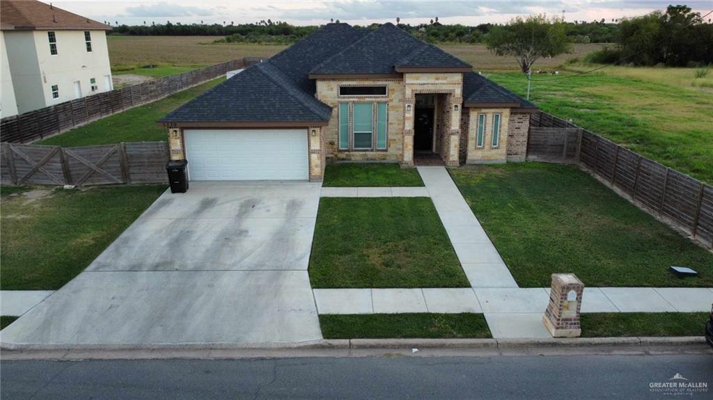 View of front facade featuring a front lawn and a garage