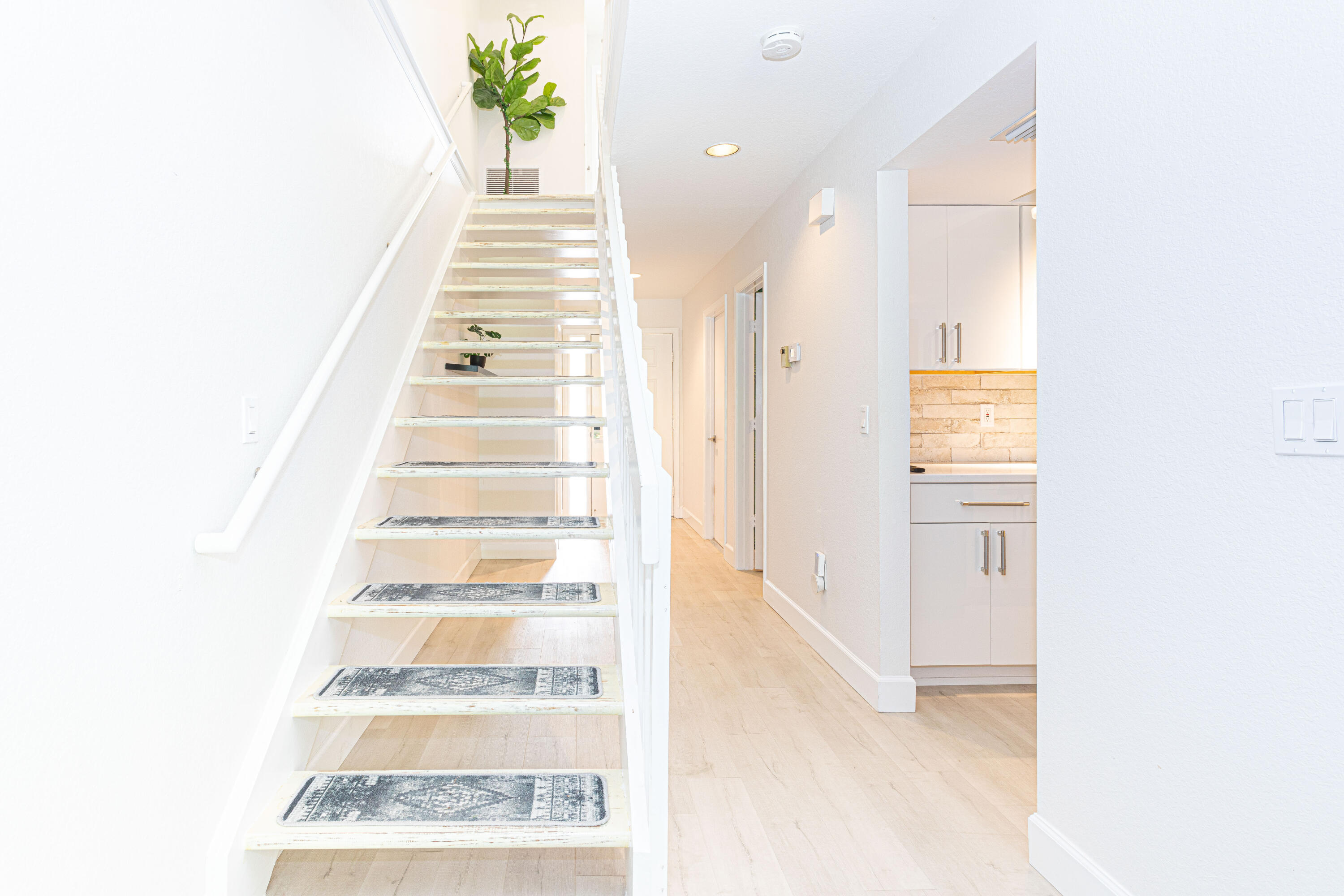 a view of a hallway with wooden floor and windows