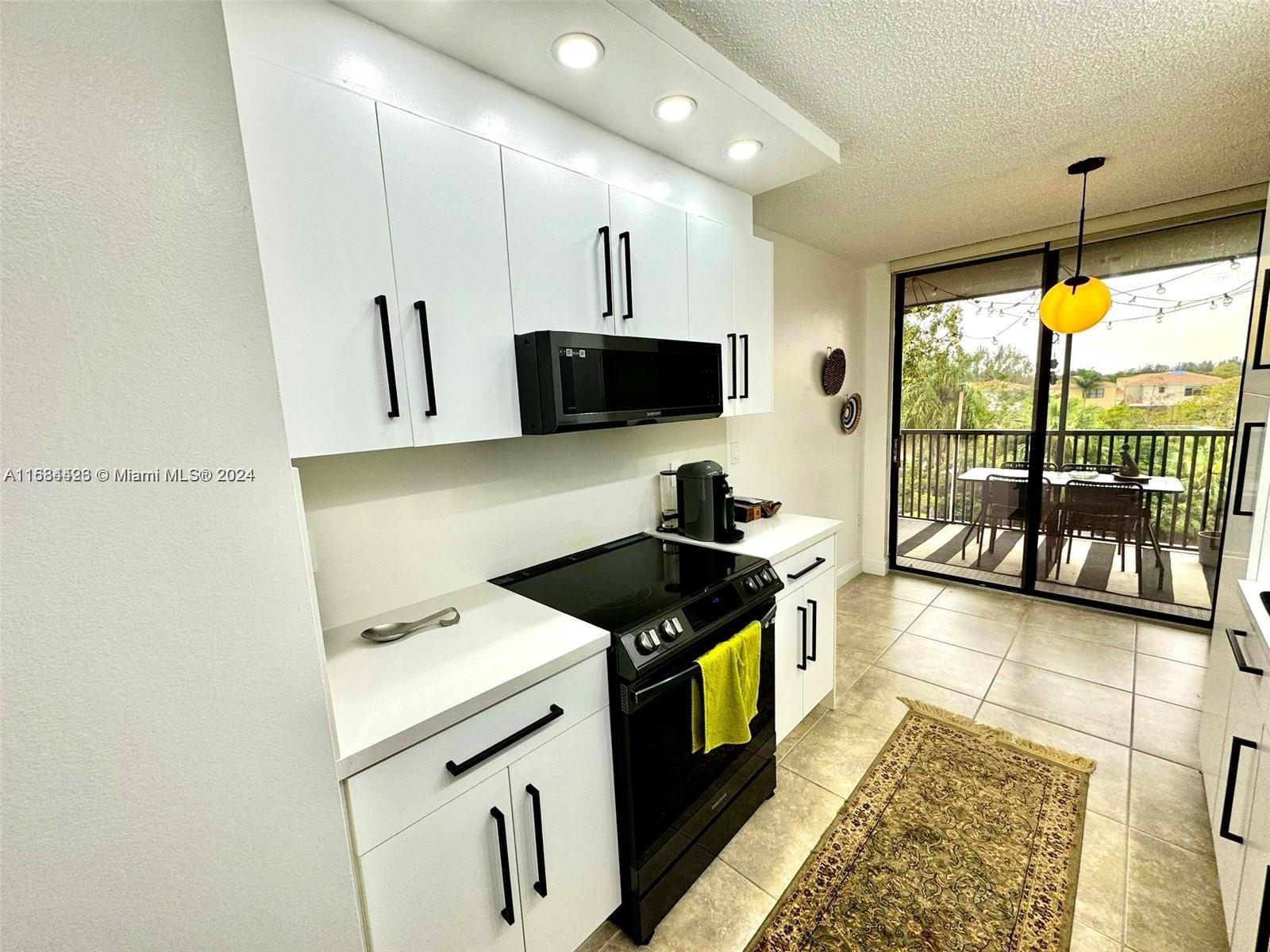 a kitchen with granite countertop a stove a sink and a microwave