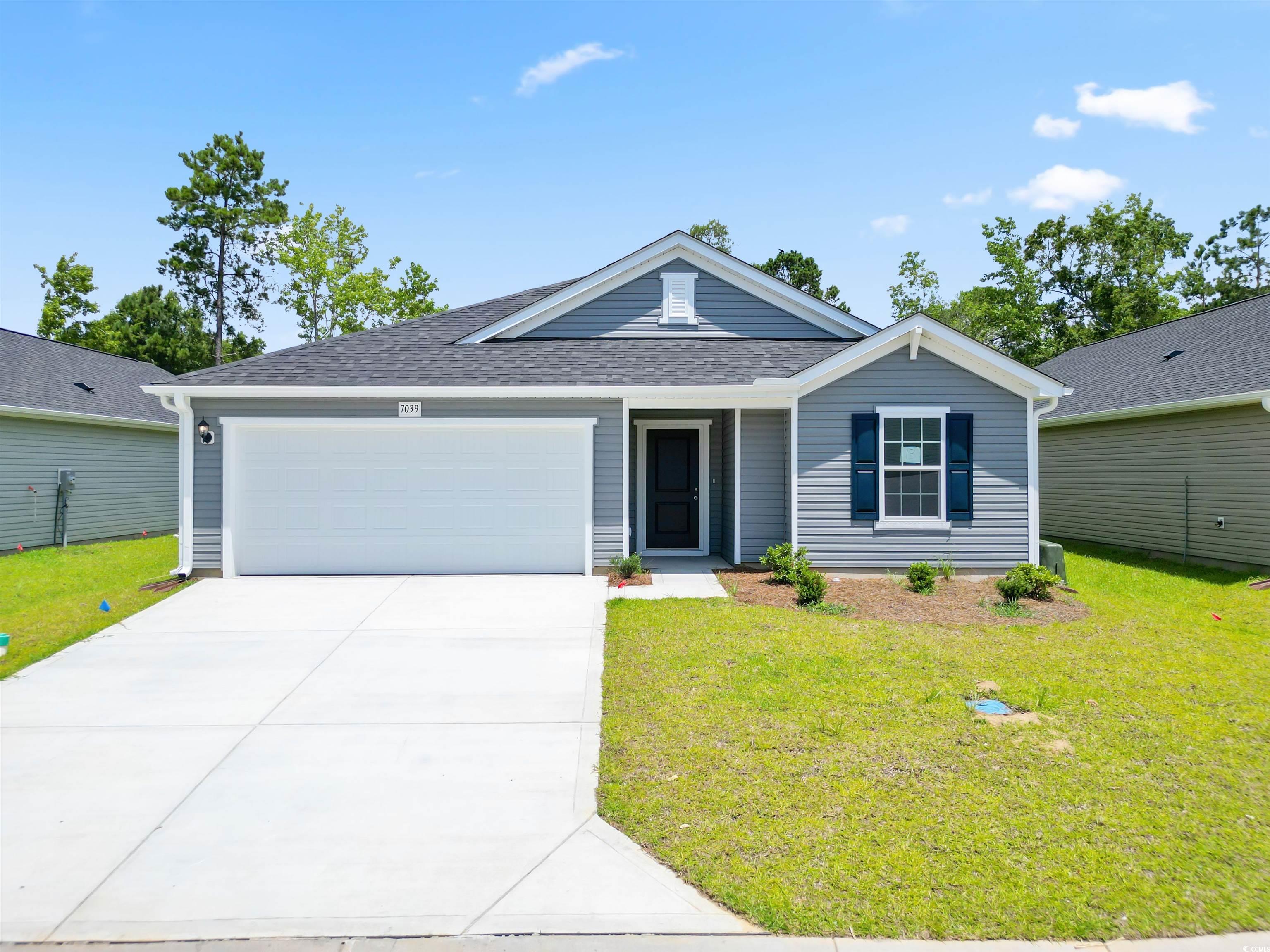 Ranch-style home featuring a front lawn and a gara