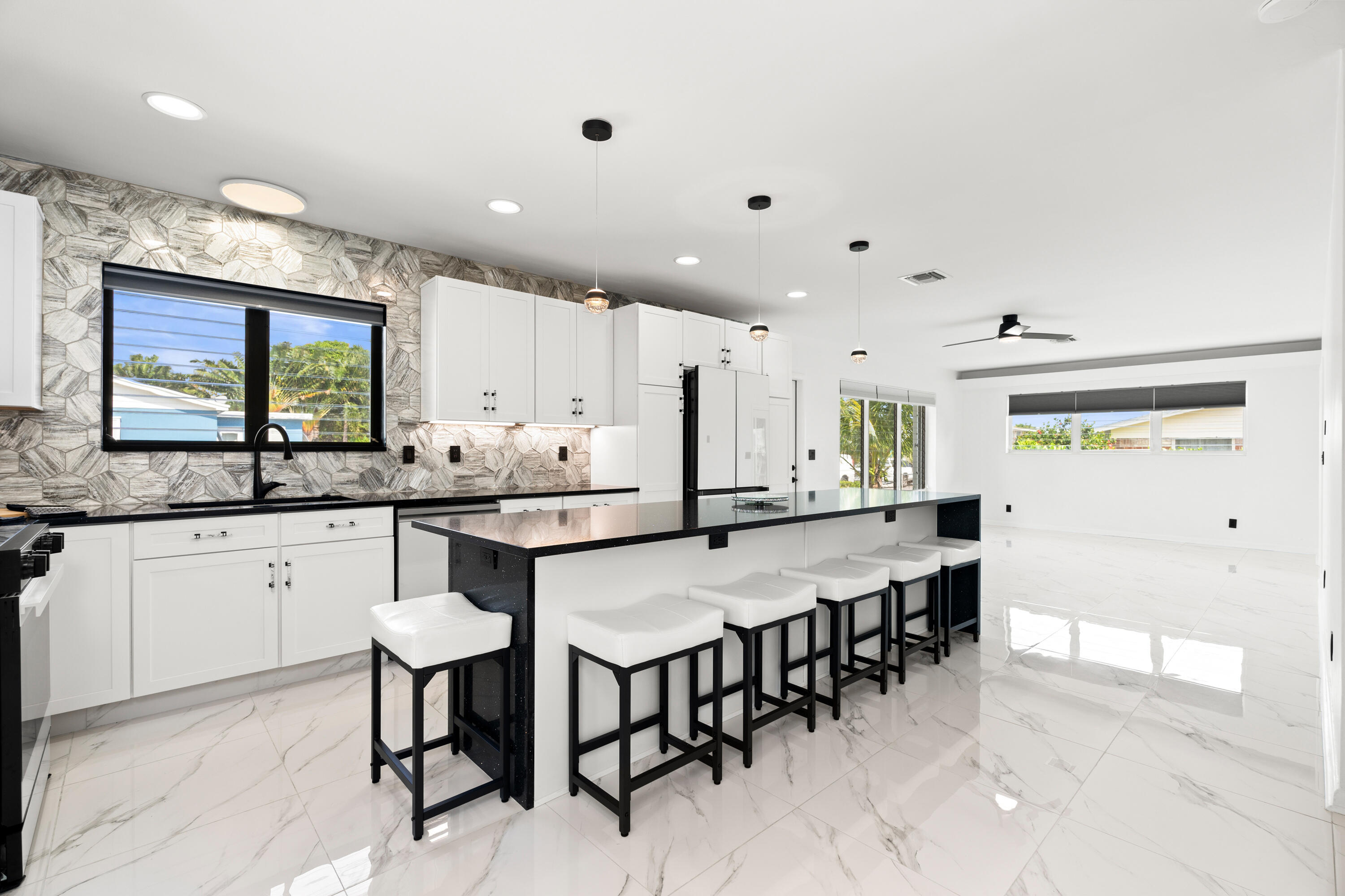 a kitchen with stainless steel appliances kitchen island granite countertop a table chairs sink and cabinets