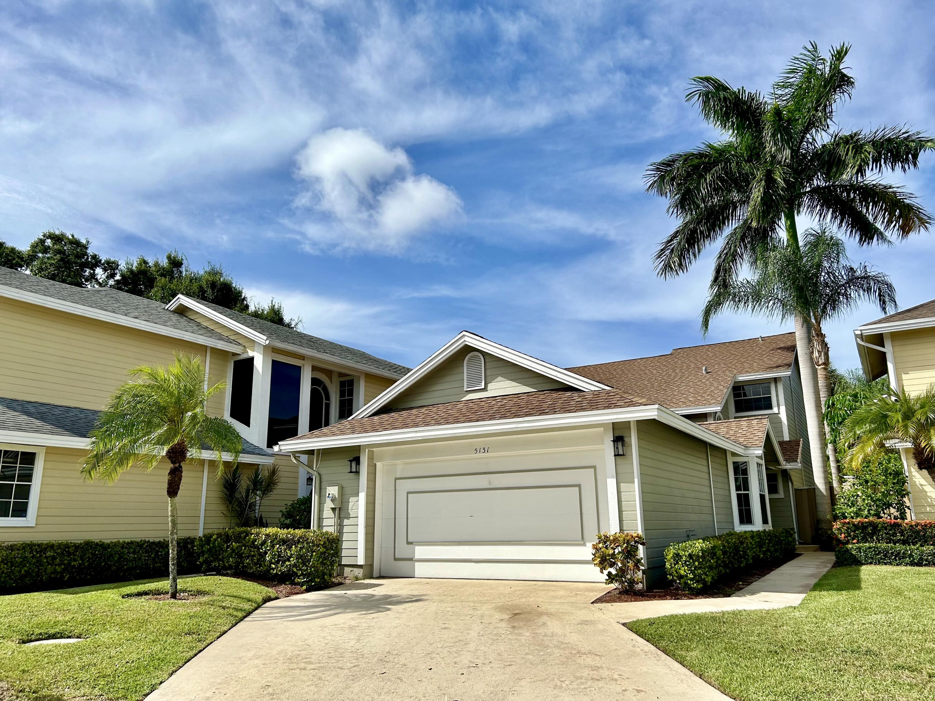 front view of house with a yard and potted plants