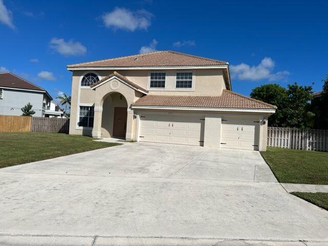 a front view of a house with yard and garage