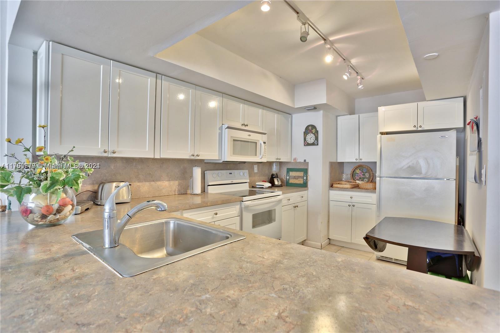 a kitchen with refrigerator cabinets and a sink