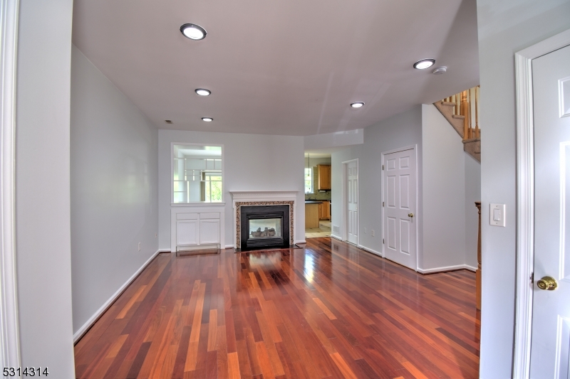 a view of empty room with wooden floor and fireplace