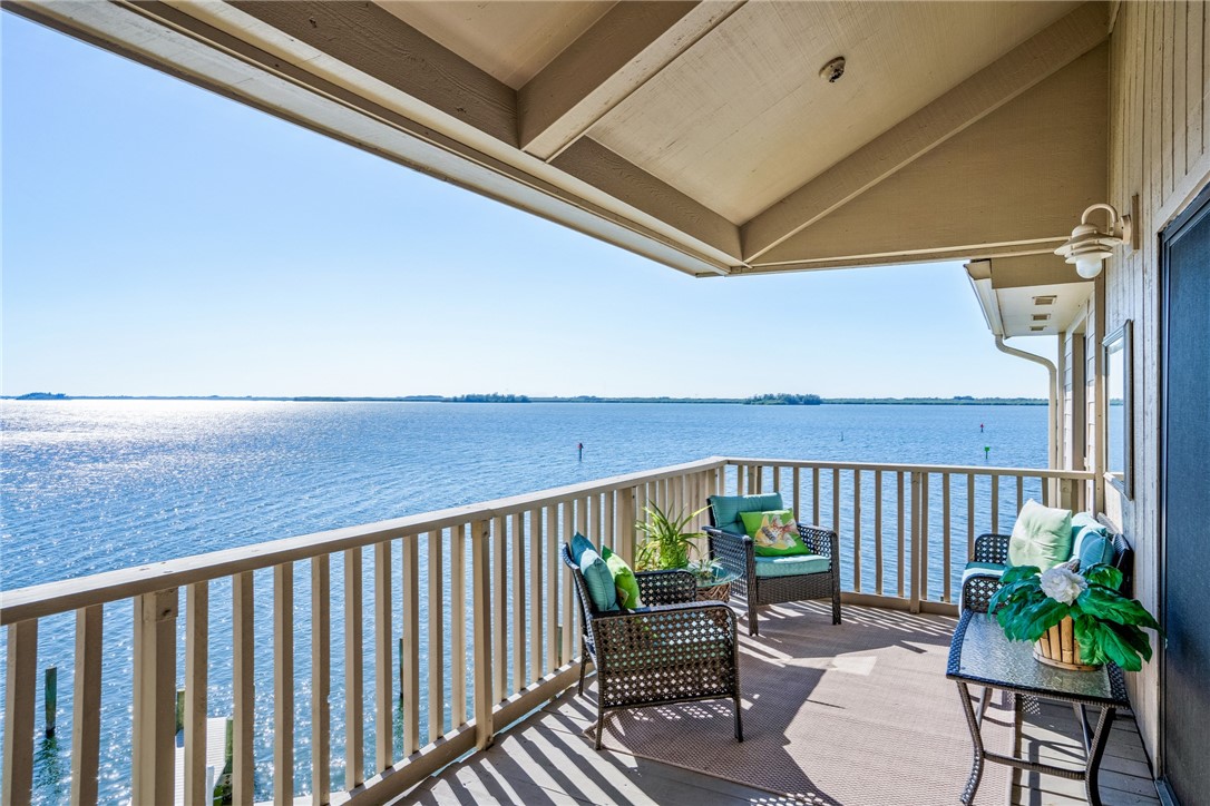 a balcony with wooden floor table and chairs