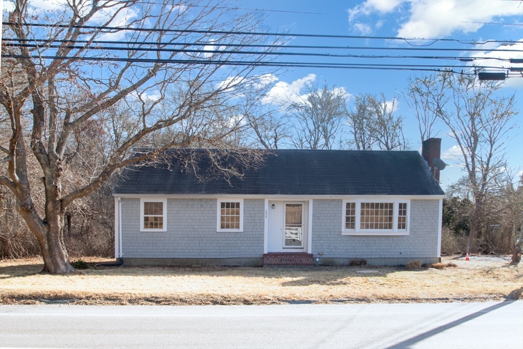 a view of a house with a yard covered with snow in the background