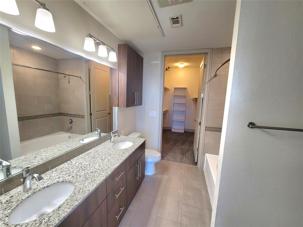 a bathroom with a granite countertop sink a mirror and a shower