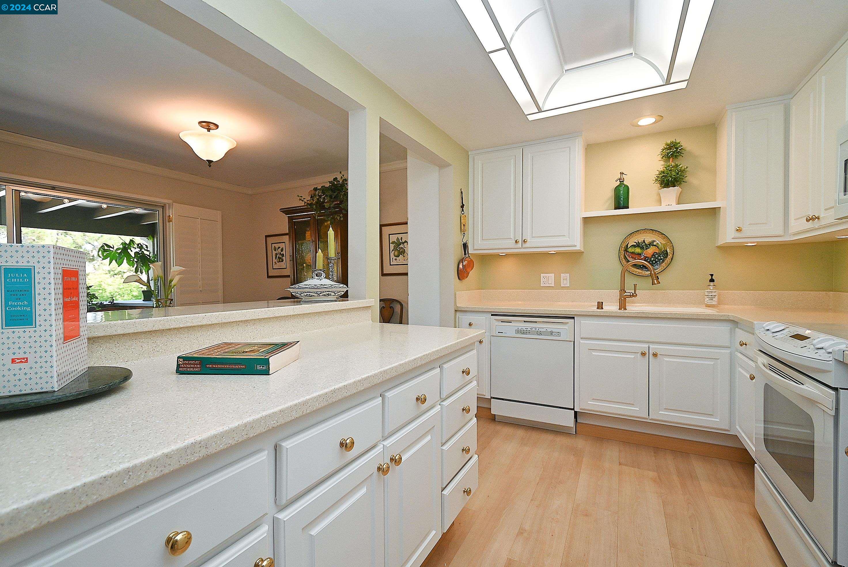 a kitchen with kitchen island white cabinets and white appliances