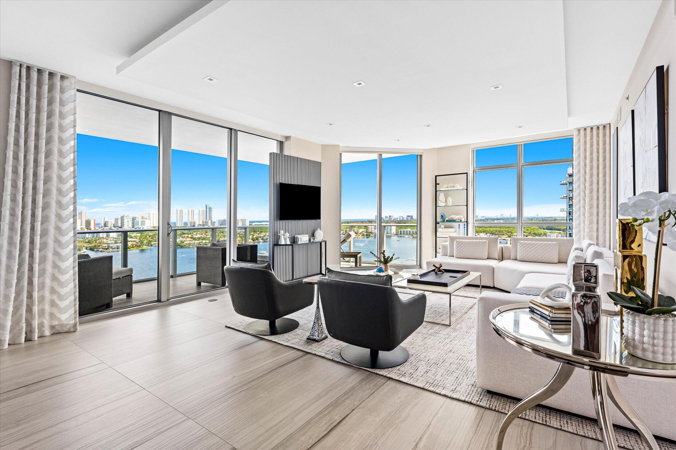 a living room with furniture a flat screen tv and a floor to ceiling window