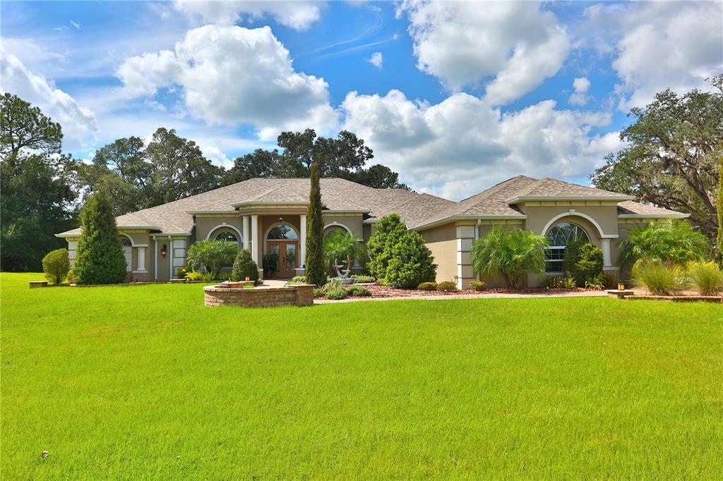 a front view of house with yard and green space