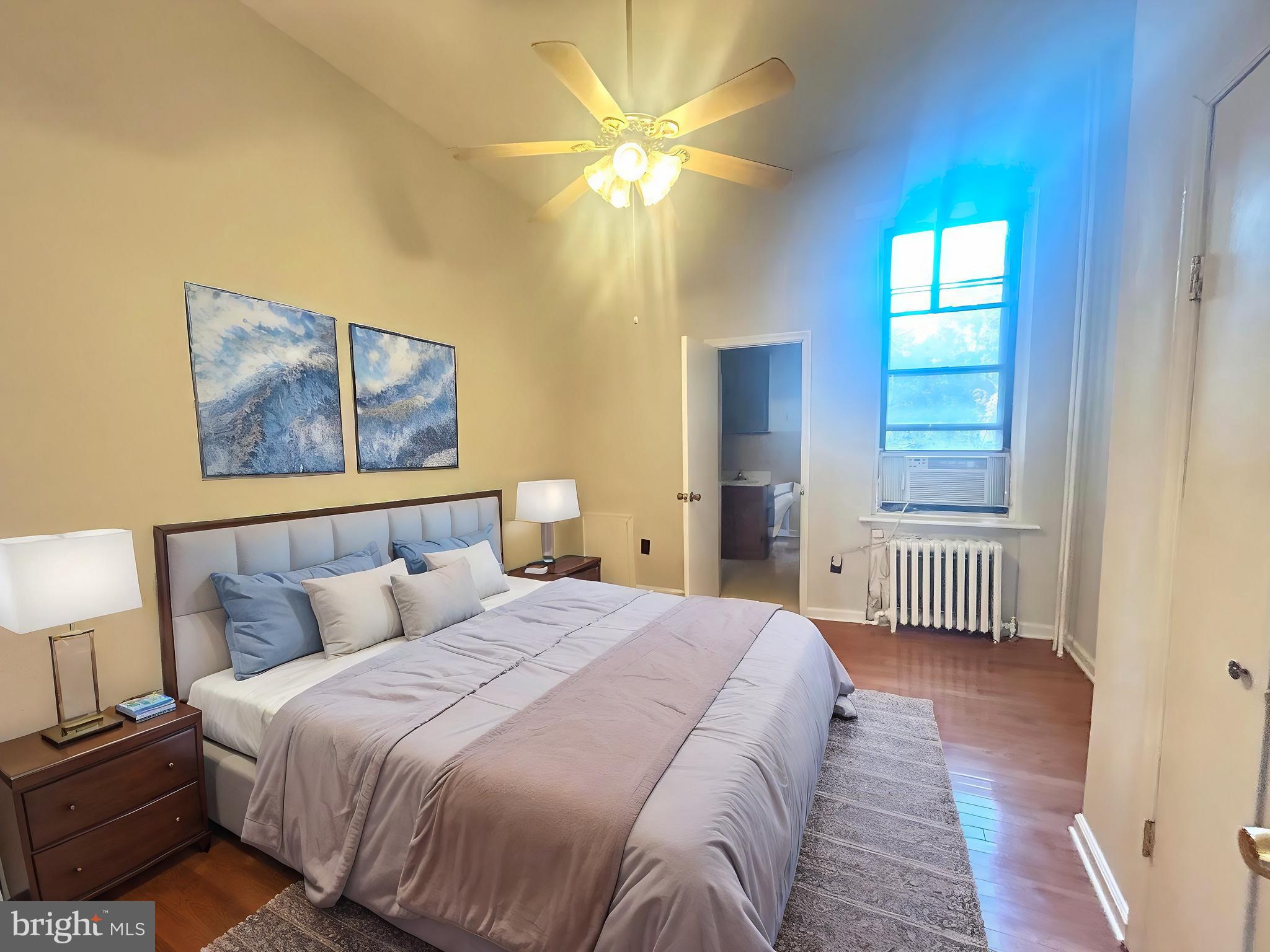 a bedroom with a bed and a painting on the wall