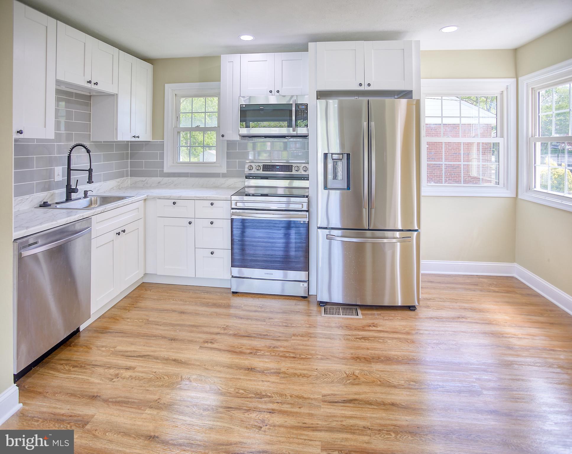 a kitchen with stainless steel appliances granite countertop a refrigerator sink and microwave