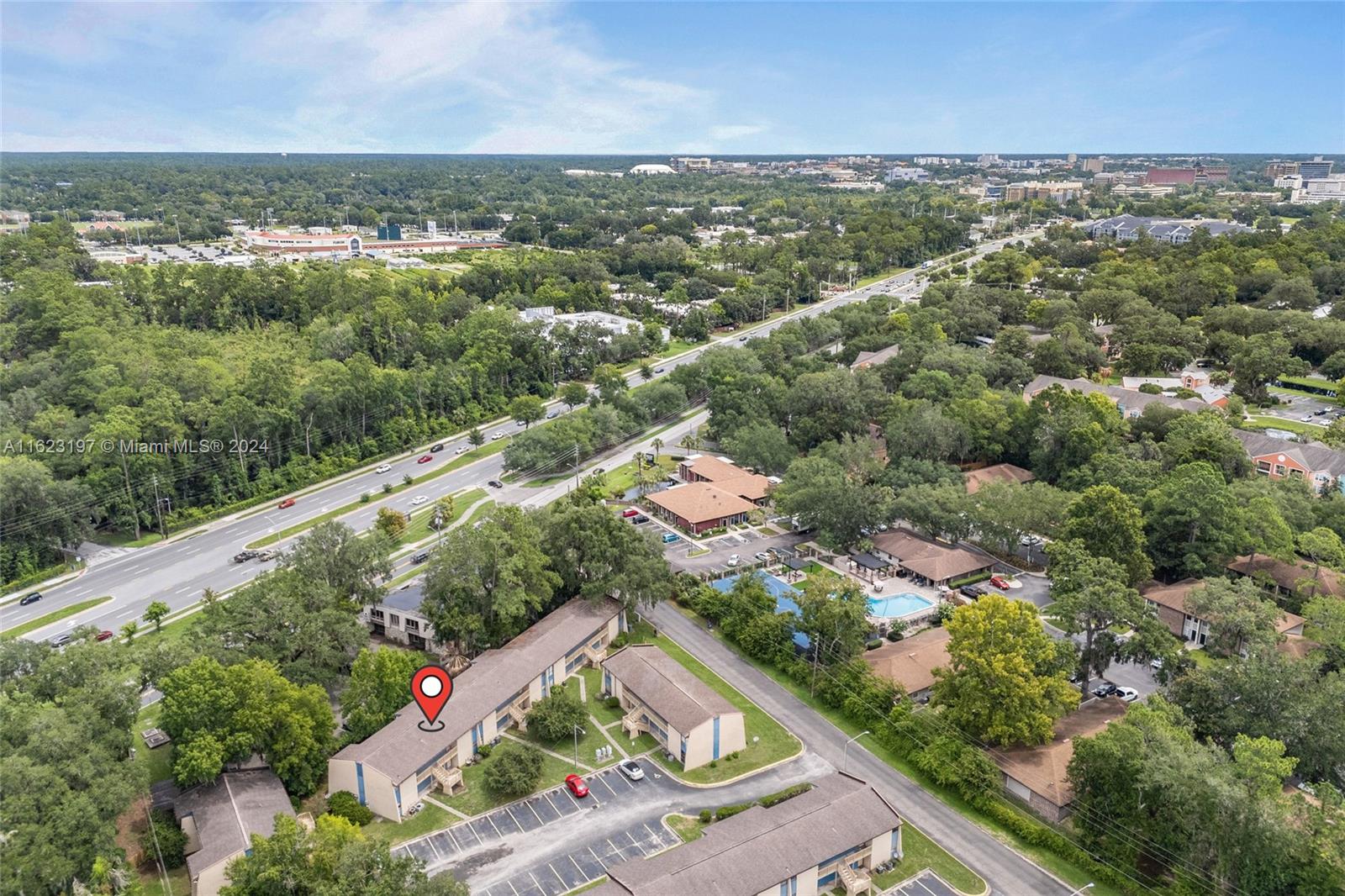 an aerial view of residential houses with outdoor space and trees