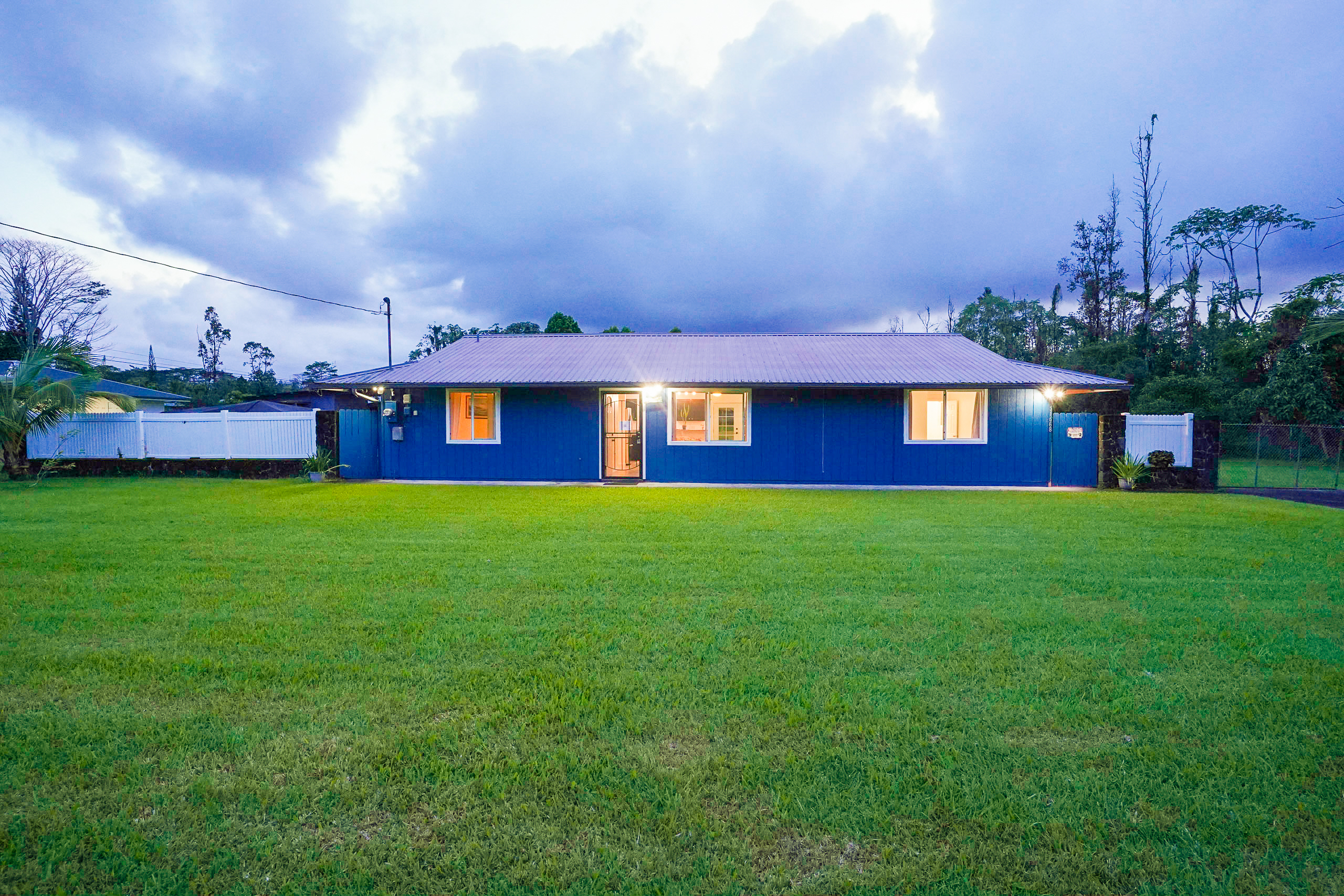 a front view of a house with a yard table and large trees