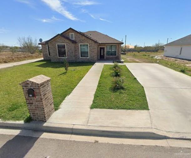 a view of a house with a yard and large tree